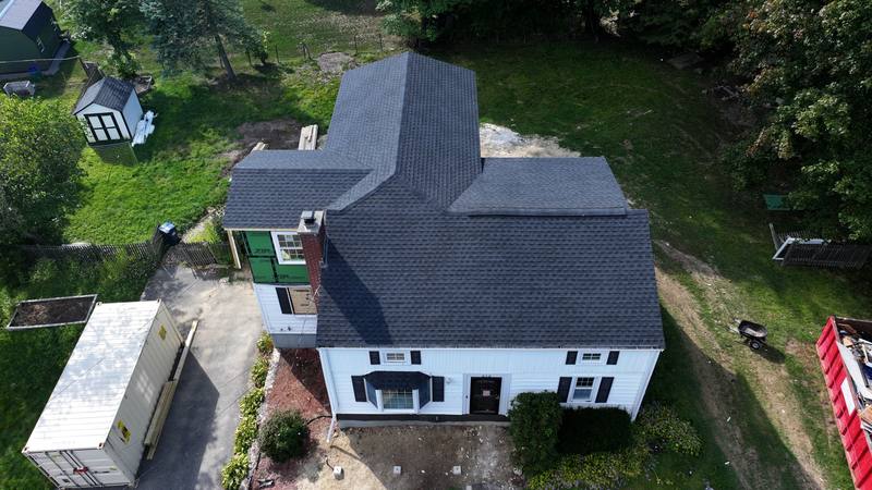 White colonial with a dark shingle roof, aerial view