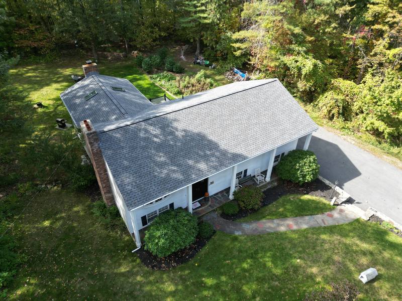 Cape with a gray shingle roof, skylights and white gutters