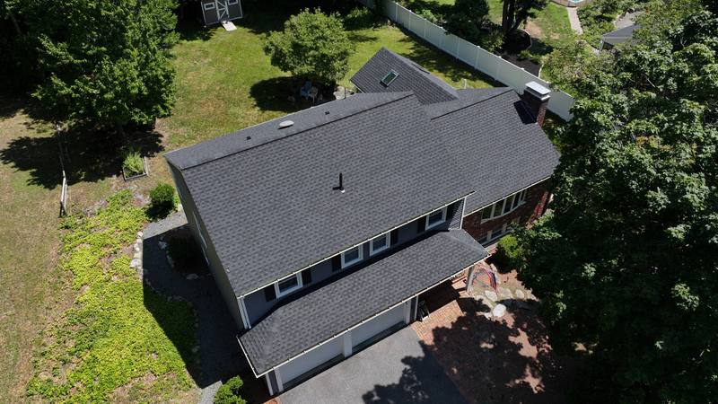 Dark shingle roof over a two-story home, aerial view